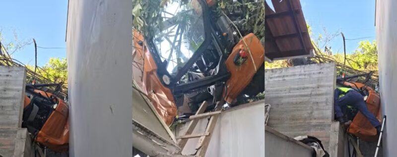 SC – Trator despenca de morro, atinge casa e motorista fica pendurada no veículo